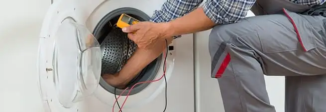 Dryer repair technician inspecting and repairing a clothes dryer in Marietta, GA