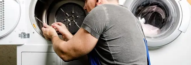 Dryer repair technician fixing a clothes dryer drum in Marietta, GA