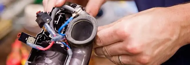 Vacuum repair technician reconnecting wiring and components in Marietta, GA