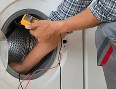 Washing machine repair technician testing a front-load washer with diagnostic tools in Marietta, GA